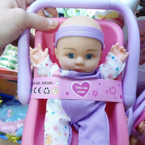 slatka lutka beba sa nosiljkom sa plavim očima